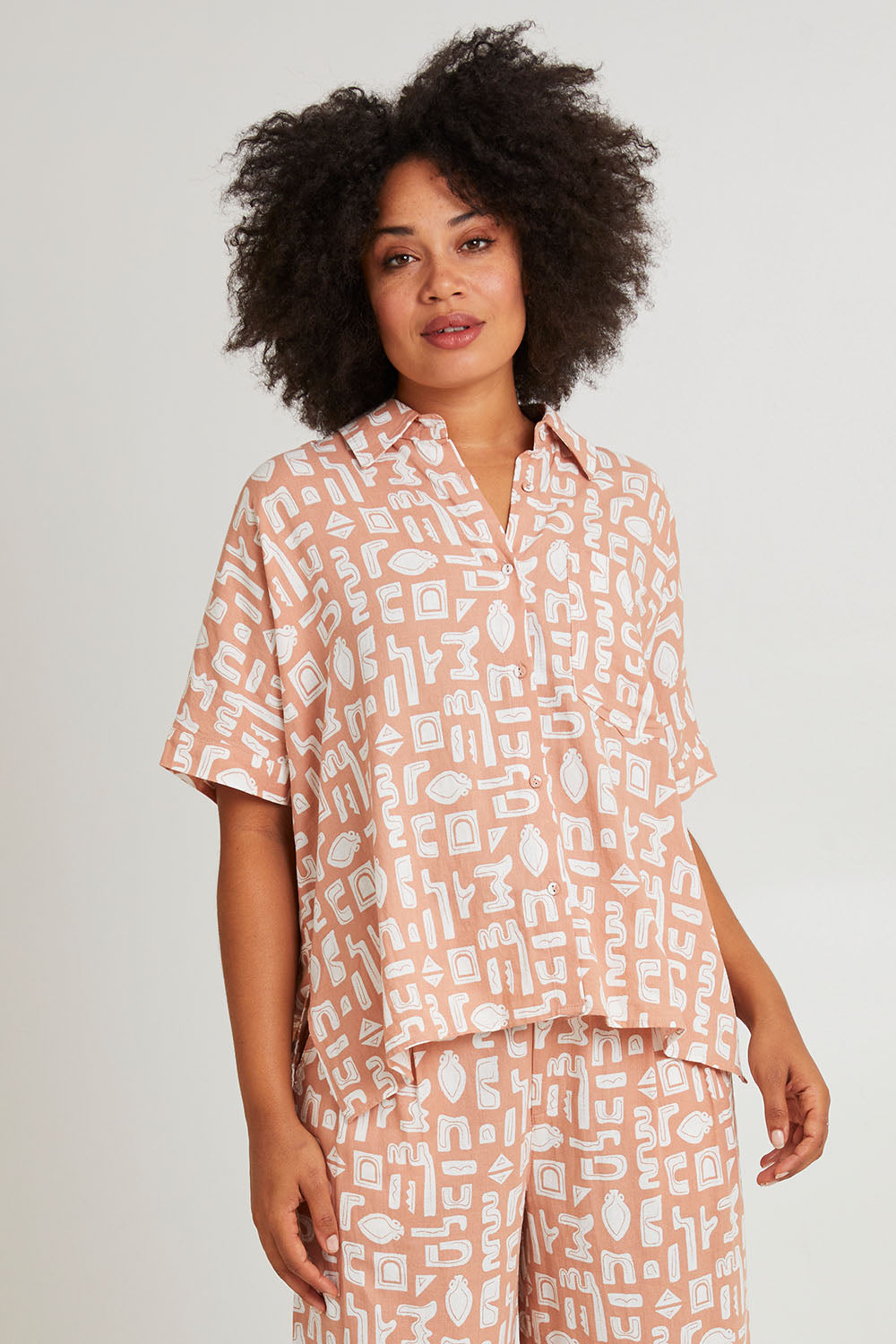 Model Olivia wearing size 10 of the Etched Geo Shirt in colour Clay, from the front, cropped image
