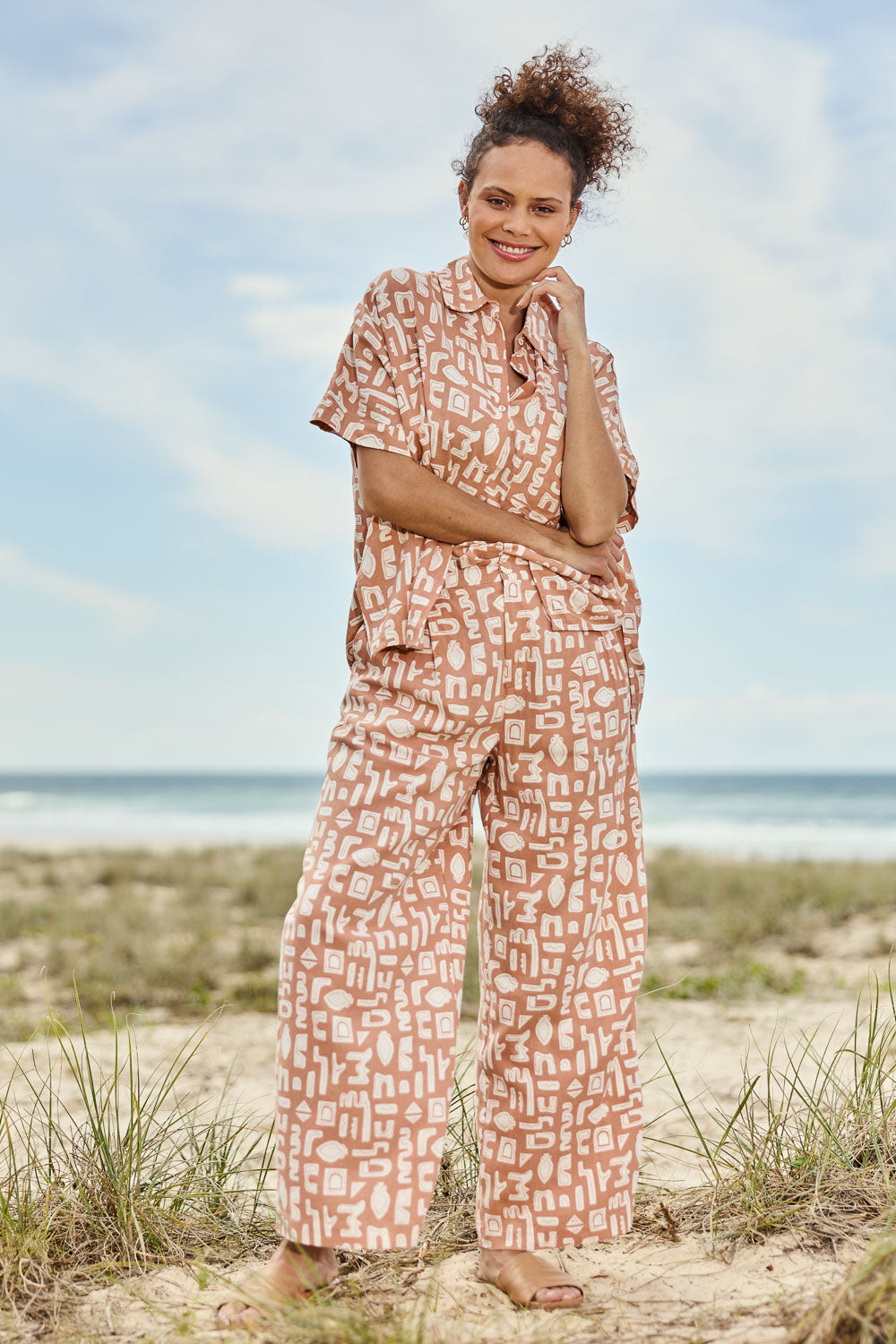 Model Lala wearing size 10 of the Etched Geo Pant in colour Clay, from the front, showing the whole outfit