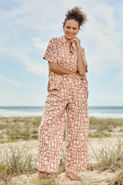 Model Lala wearing size 10 of the Etched Geo Pant in colour Clay, from the front, showing the whole outfit