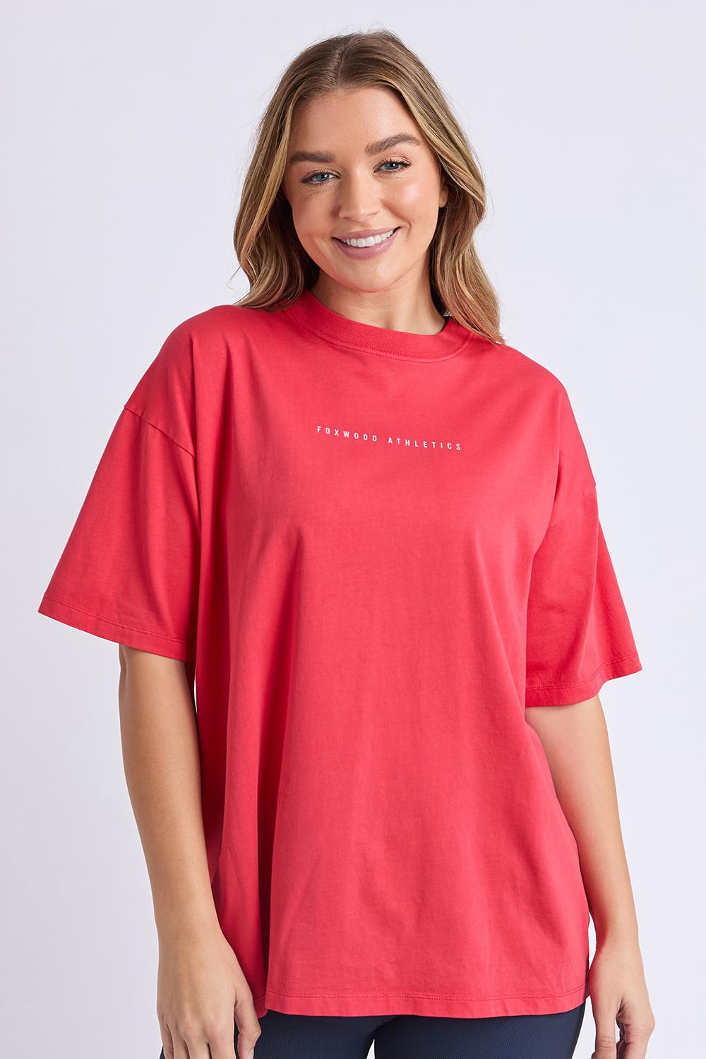 A model wearing the Leisure Captain Cotton Tee in colour Red (Red), from the front, cropped image