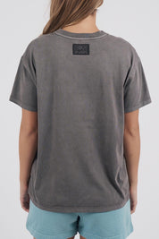 A model wearing the Leisure State League Tee in colour Iron (Grey), from the back