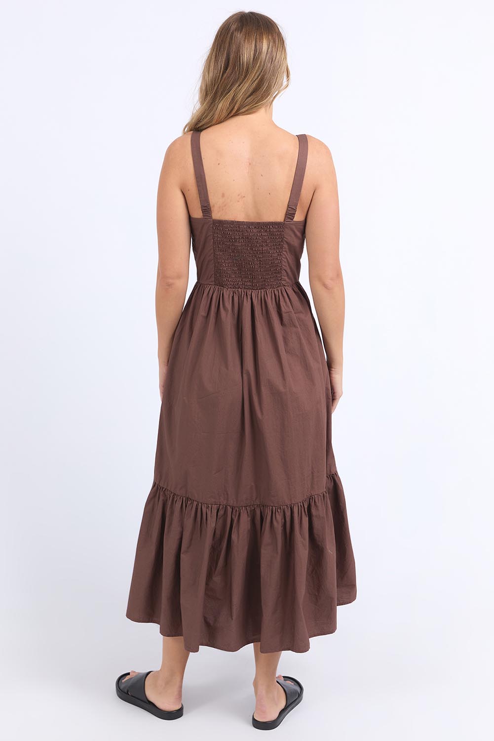 A model wearing the Esmerelda Cotton Dress in colour Chocolate, from the back