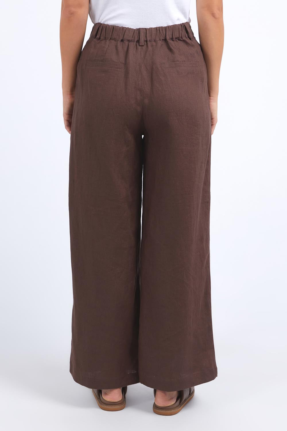 A model wearing the Pierra Linen Pant in colour Chocolate, from the back
