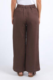A model wearing the Pierra Linen Pant in colour Chocolate, from the back
