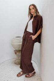 A model wearing the Pierra Linen Pant in colour Chocolate, from the front, showing the whole outfit