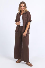 A model wearing the Pierra Linen Pant in colour Chocolate, from the front, showing the whole outfit