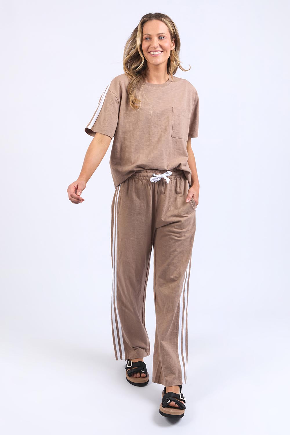 A model wearing the Leisure Power Cotton Pant in colour Mocha, from the front, showing the whole outfit