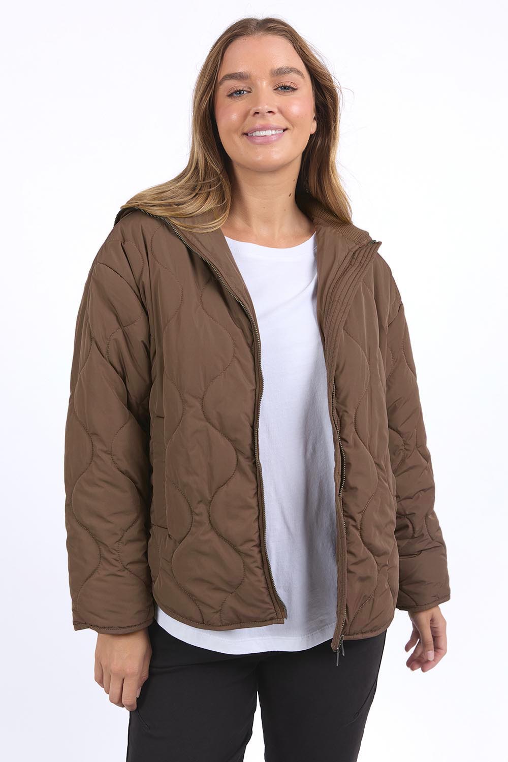 A model wearing the Mellow Quilted Jacket in colour Coffee, from the front, cropped image