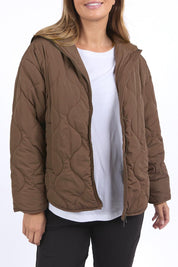 A model wearing the Mellow Quilted Jacket in colour Coffee, from the front, cropped image