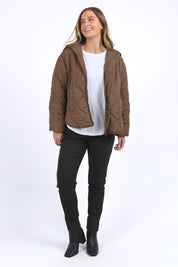 A model wearing the Mellow Quilted Jacket in colour Coffee, from the front, showing the whole outfit