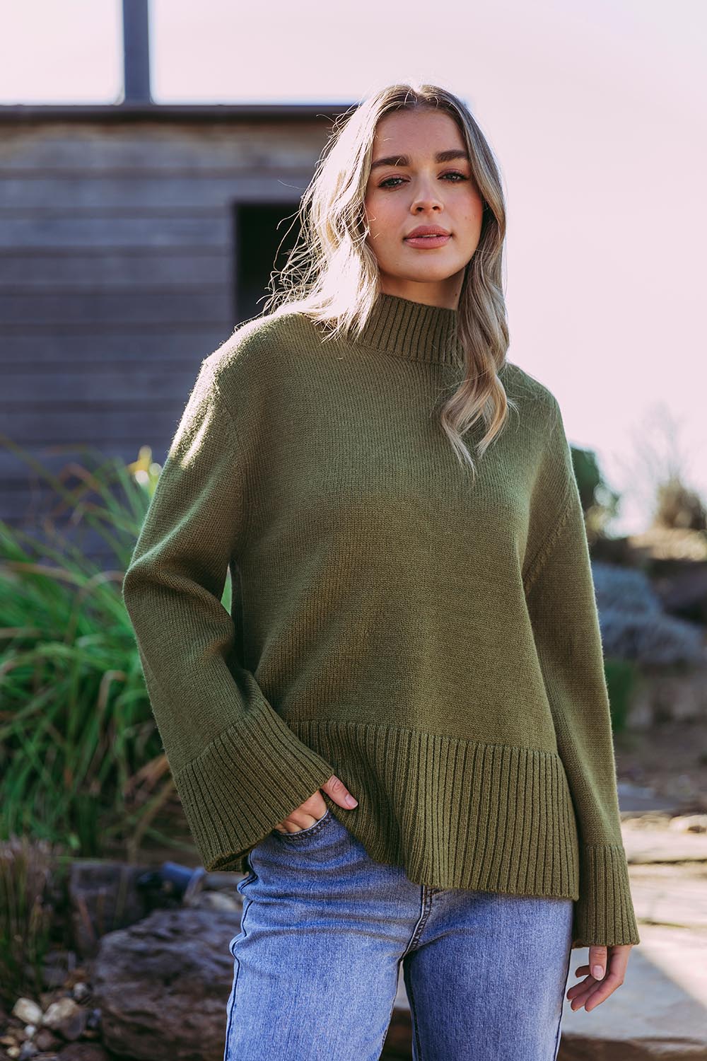A model wearing the Jude Wool Blend Knit in colour Olivegree (Green), from the front, showing the whole outfit