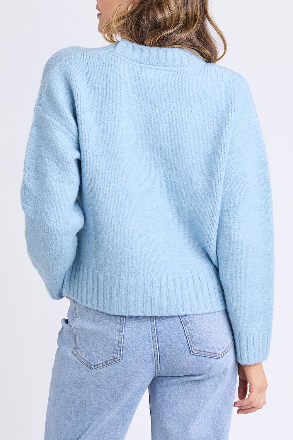 A model wearing the Jensen Button Cardi in colour Celestialb (Blue), from the back
