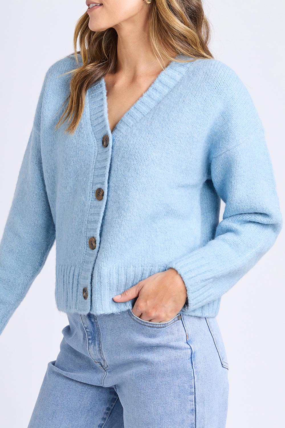 A model wearing the Jensen Button Cardi in colour Celestialb (Blue), from the front, cropped image