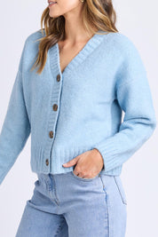 A model wearing the Jensen Button Cardi in colour Celestialb (Blue), from the front, cropped image