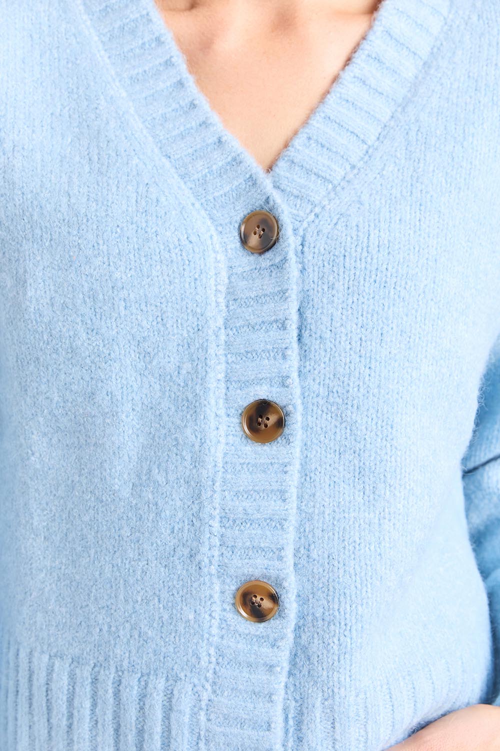 A model wearing the Jensen Button Cardi in colour Celestialb (Blue), from the front, cropped image