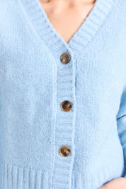 A model wearing the Jensen Button Cardi in colour Celestialb (Blue), from the front, cropped image