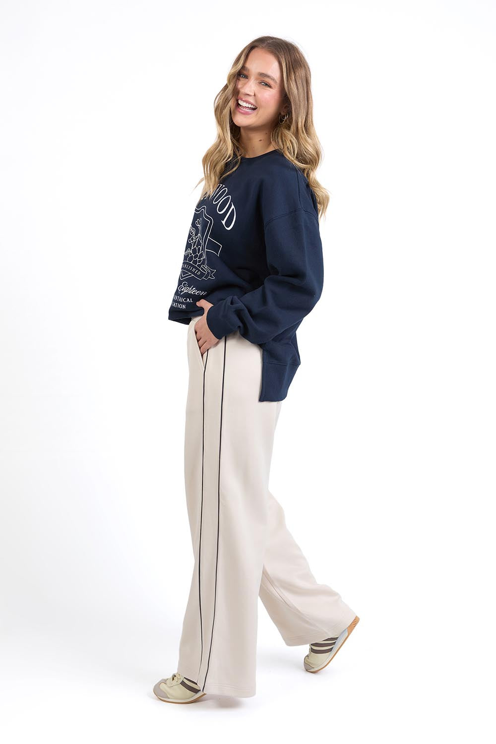 A model wearing the Traveller Pant in colour Bone, from the front, showing the whole outfit