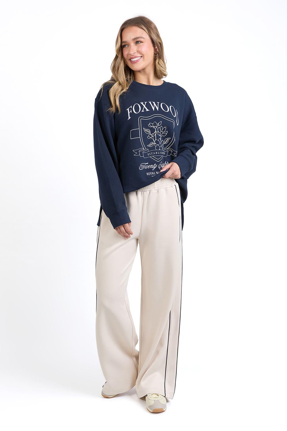 A model wearing the Traveller Pant in colour Bone, from the front, showing the whole outfit