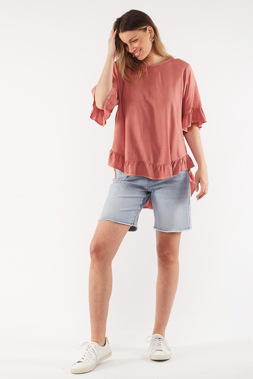 A model wearing the Cassis Top in colour Rose (Pink), from the front, showing the whole outfit