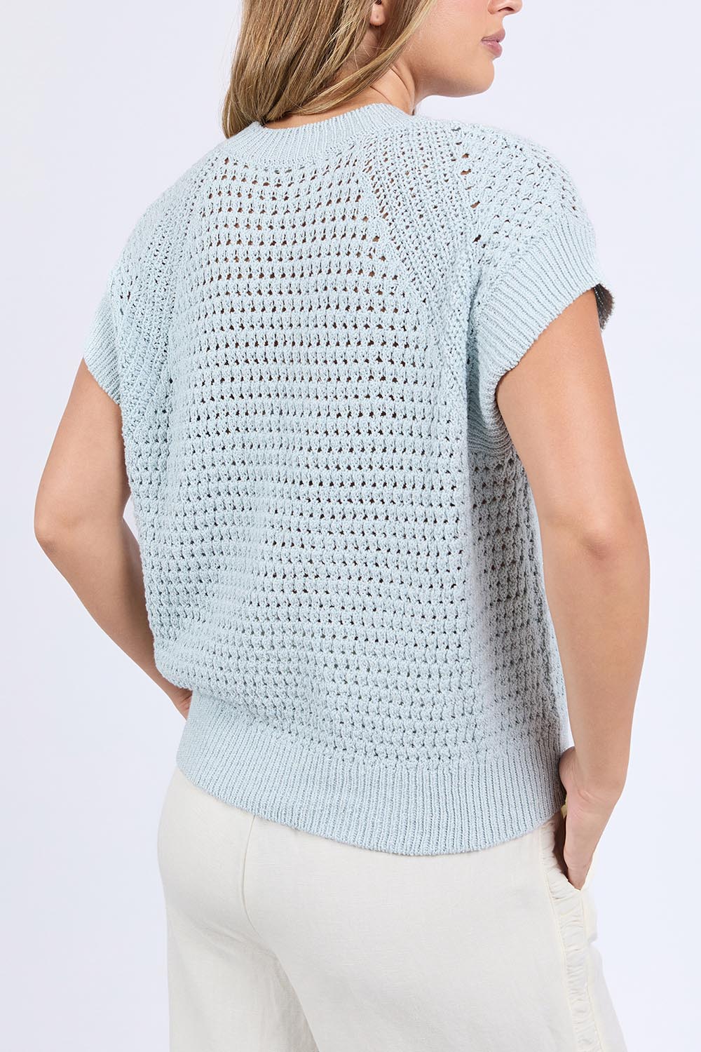 A model wearing the Isla Knit Vest in colour Balladblue (Blue), from the back