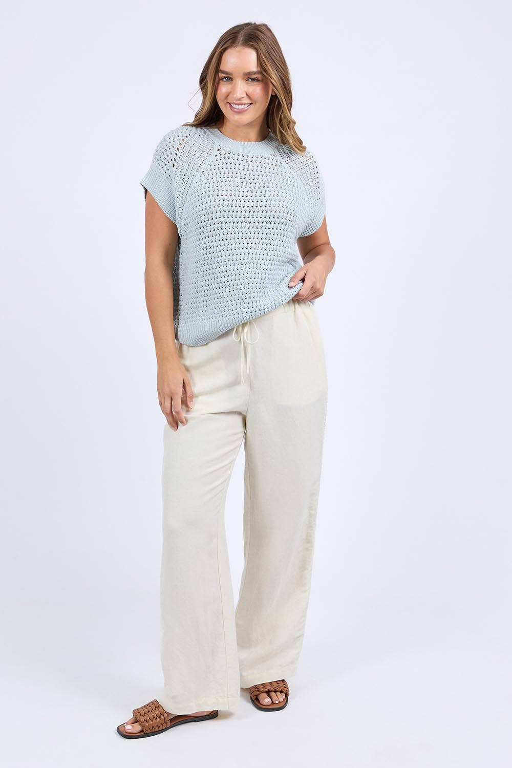 A model wearing the Isla Knit Vest in colour Balladblue (Blue), from the front, showing the whole outfit