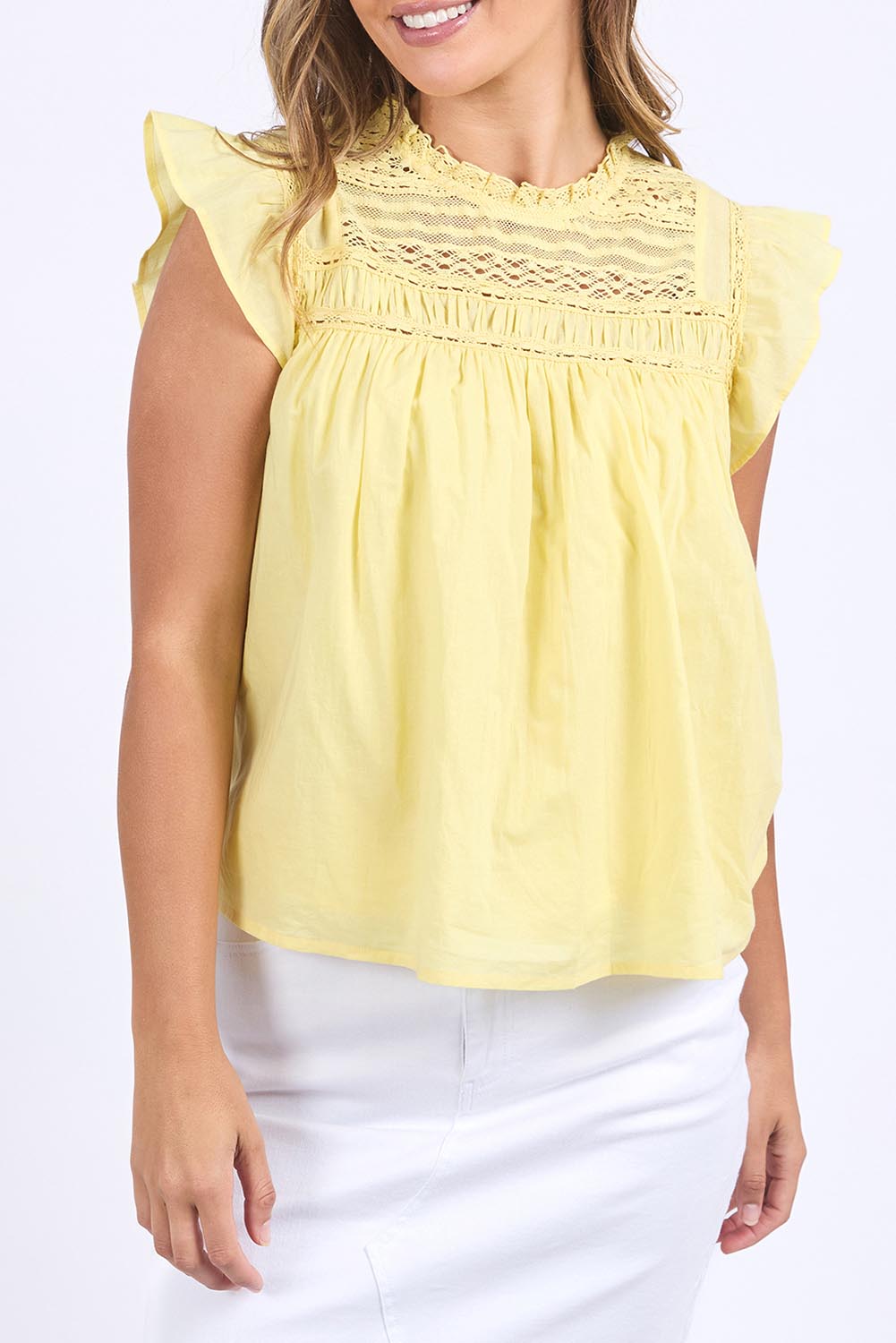 A model wearing the Adelyn Cotton Top in colour Lemon, from the front, cropped image