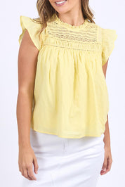 A model wearing the Adelyn Cotton Top in colour Lemon, from the front, cropped image
