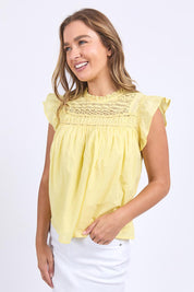 A model wearing the Adelyn Cotton Top in colour Lemon, from the front, cropped image