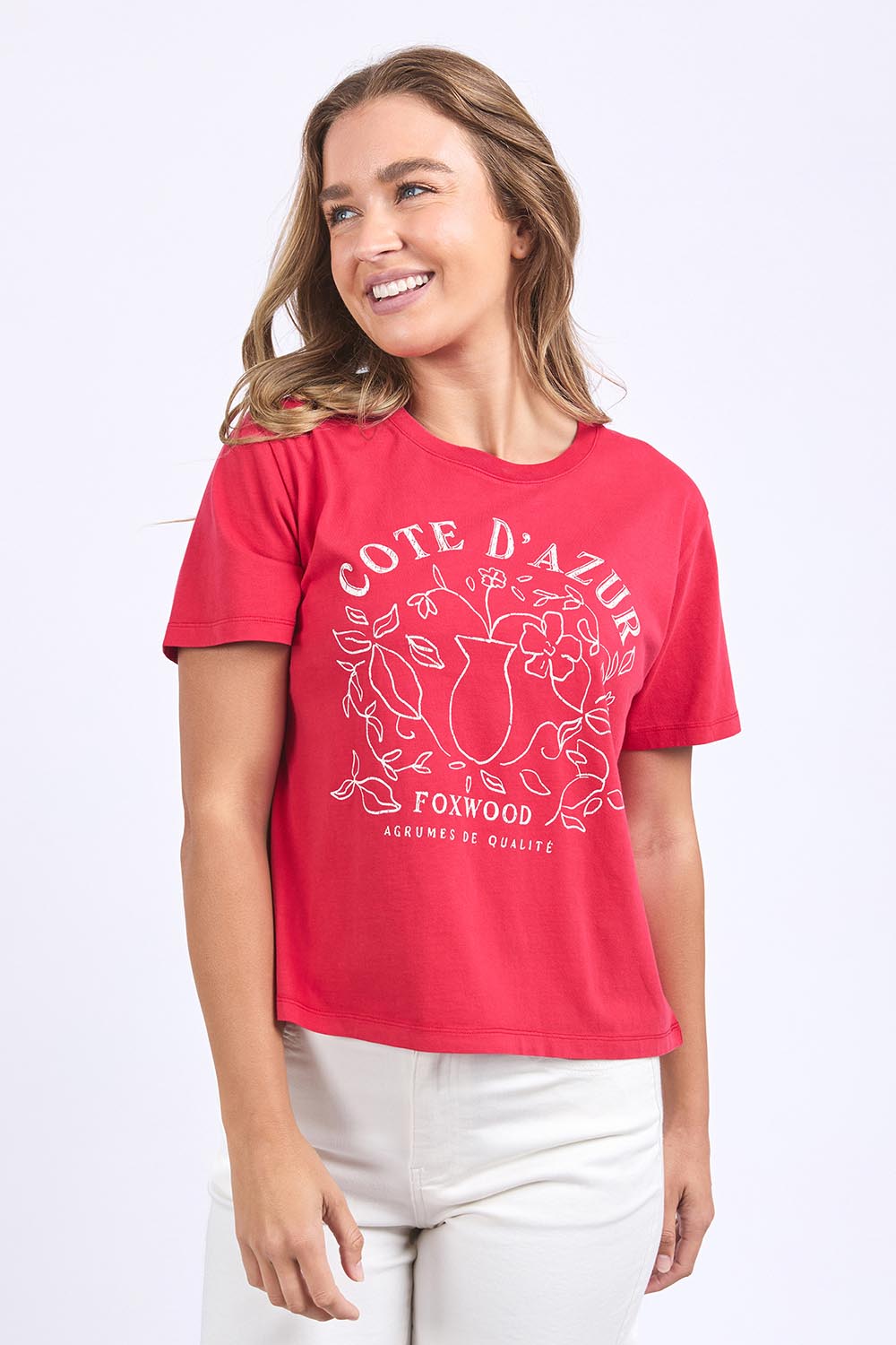 A model wearing the Cote D'azur Cotton Tee in colour Crimson (Red), from the front, cropped image