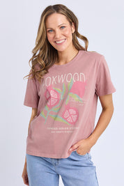 A model wearing the Pomegranate Cotton Tee in colour Ashrose (Pink), from the front, cropped image