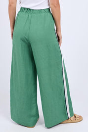 A model wearing the Elemental Linen Blend Pant in colour Deepgrass (Green), from the back