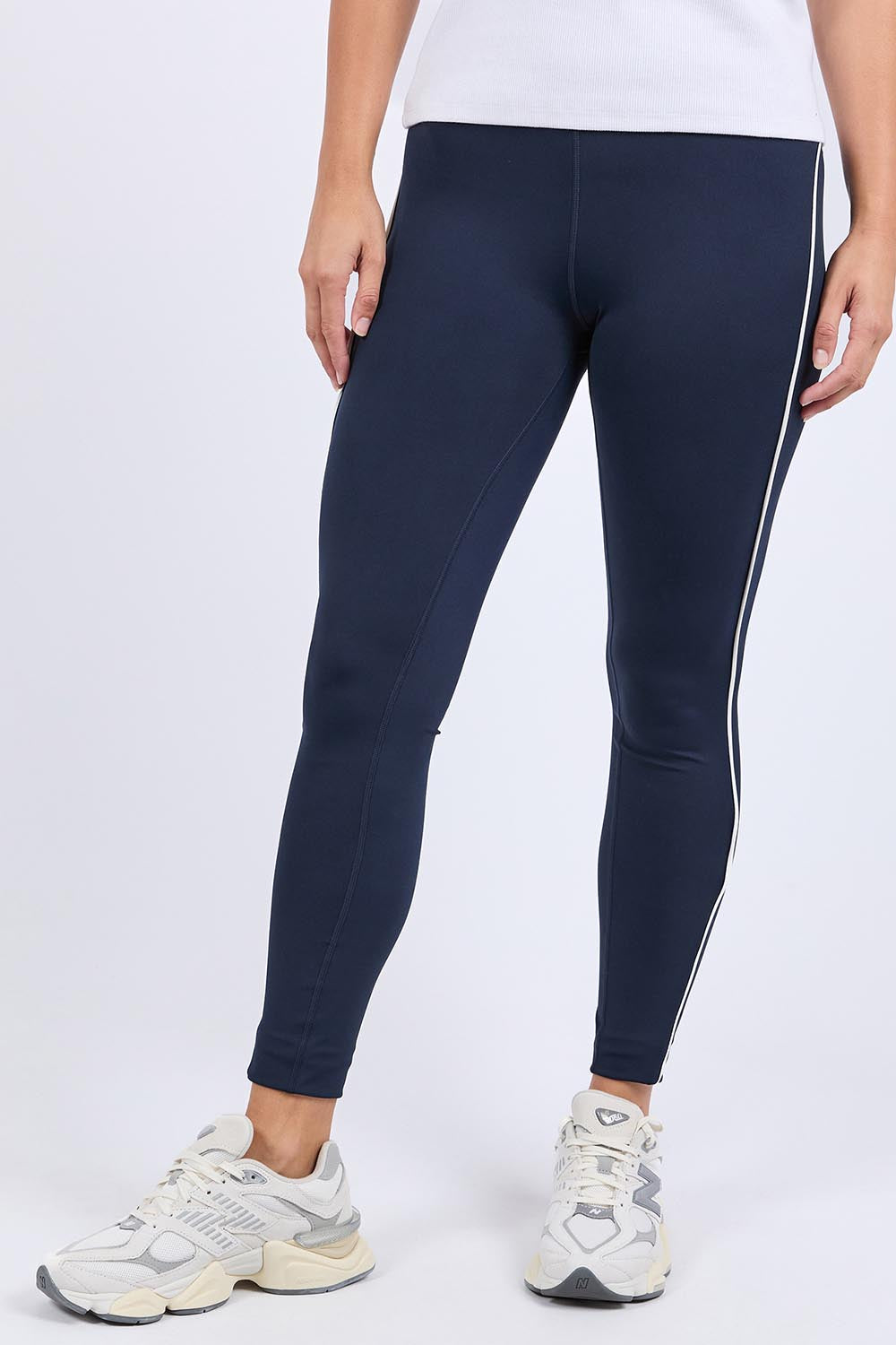 A model wearing the Elements Piping Leggings in colour Navy (Blue), from the front, cropped image