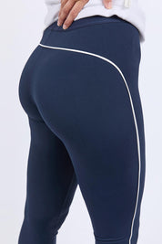 A model wearing the Elements Piping Leggings in colour Navy (Blue), from the front, cropped image