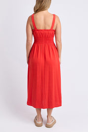 A model wearing the Dandelion Cotton Blend Dress in colour Tangelo, from the back