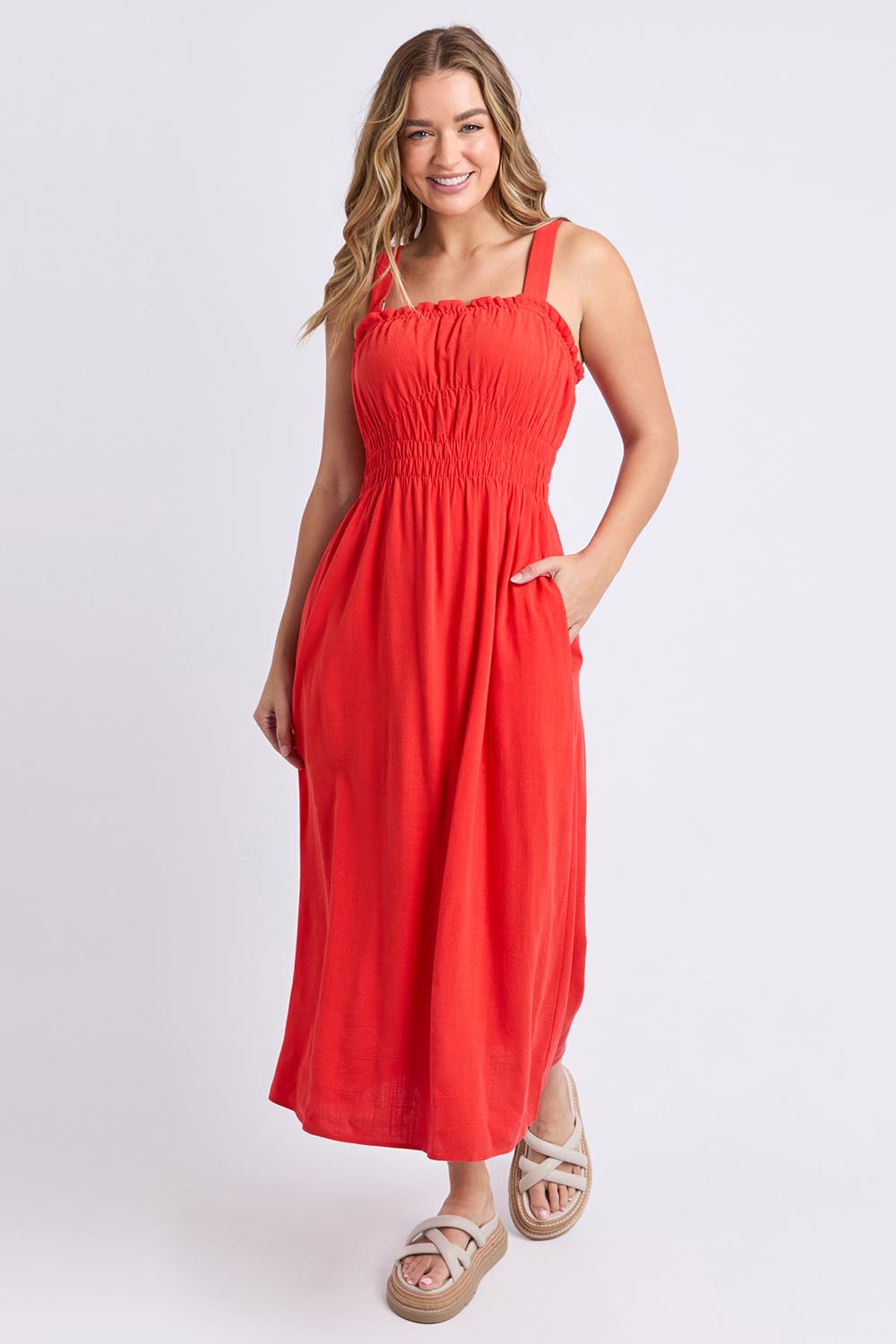A model wearing the Dandelion Cotton Blend Dress in colour Tangelo, from the front, showing the whole outfit