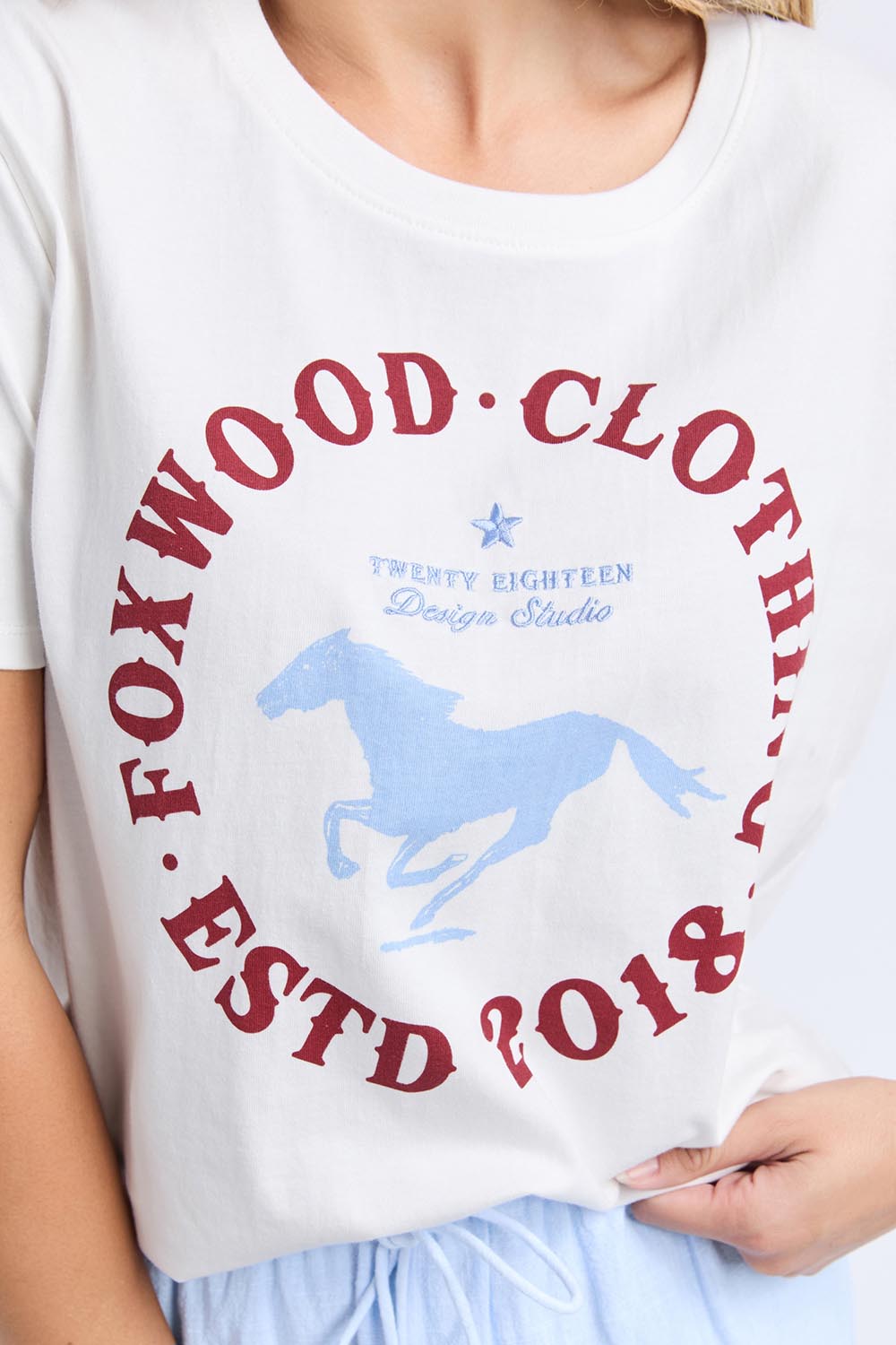 A model wearing the Est 2018 Cotton Tee in colour Vintgwht (White), from the front, cropped image