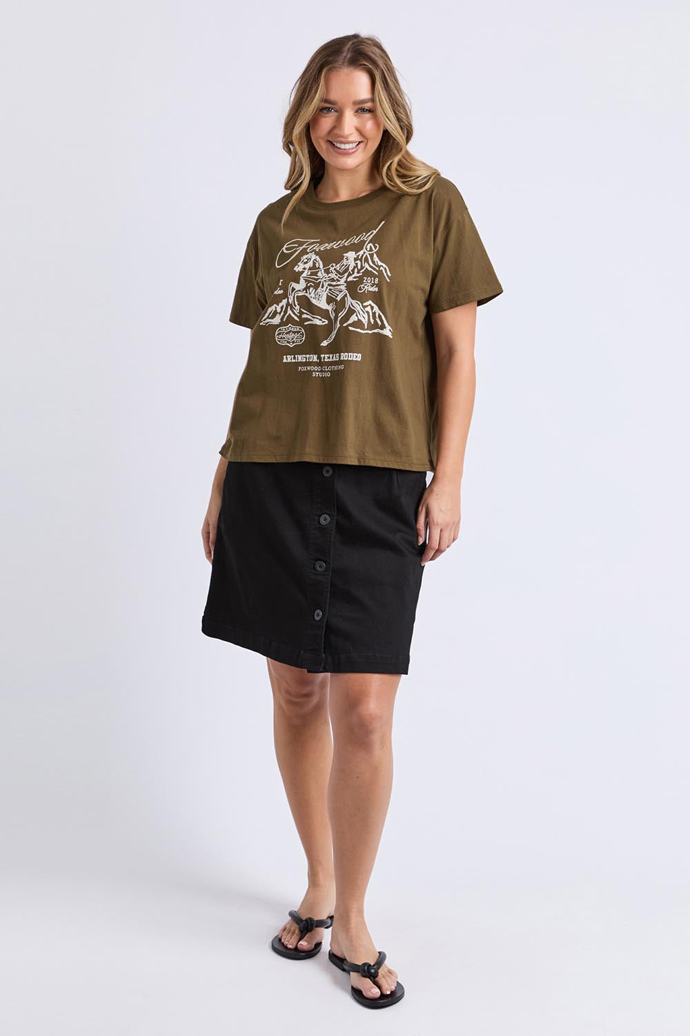 A model wearing the Arlington Cotton Tee in colour Darkolive (Green), from the front, showing the whole outfit