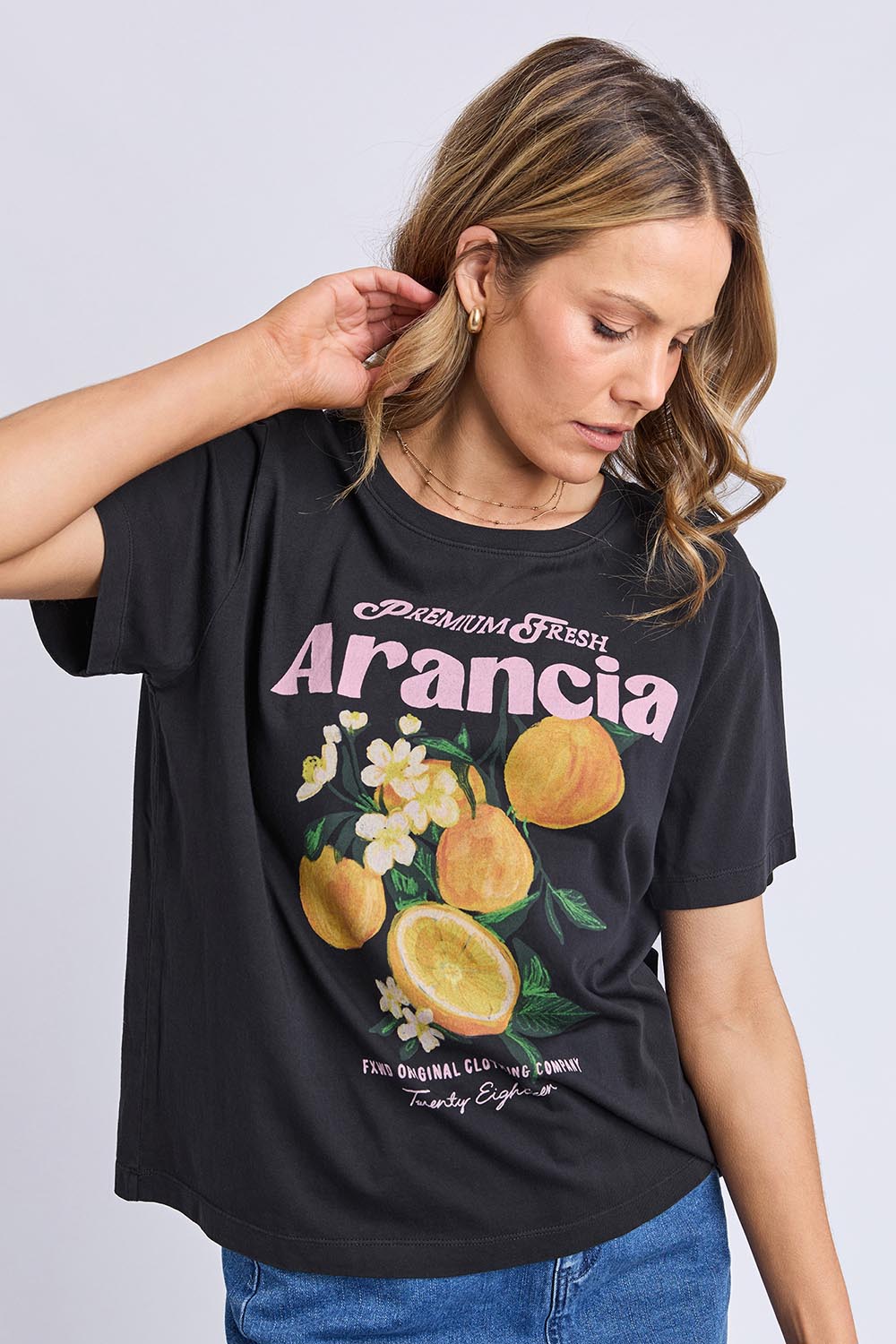 A model wearing the Arancia Cotton Tee in colour Wshedblk (Black), from the front, cropped image