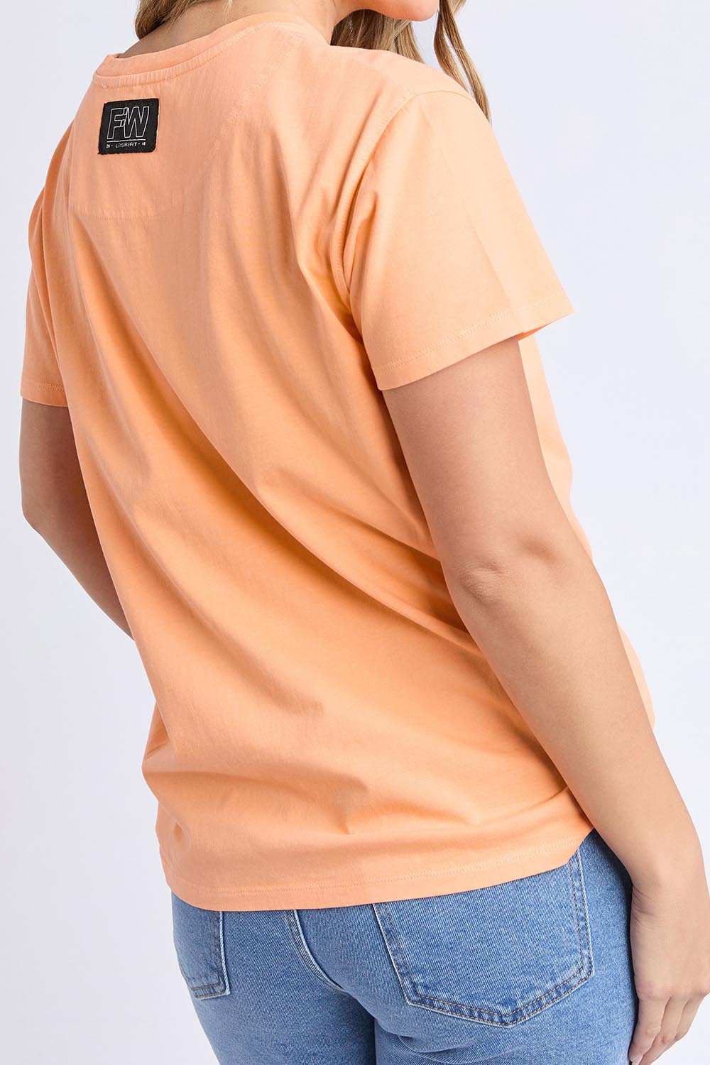 A model wearing the LA Aths Cotton Tee in colour Peach, from the back