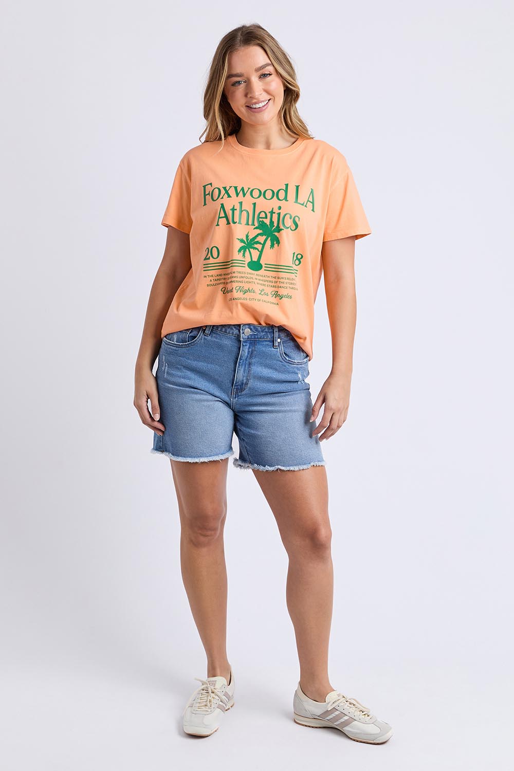 A model wearing the LA Aths Cotton Tee in colour Peach, from the front, showing the whole outfit