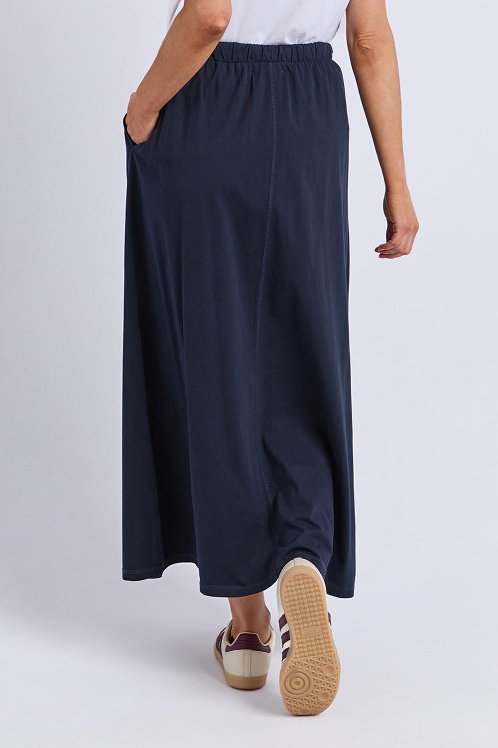 A model wearing the Evolve Cotton Skirt in colour Navy (Blue), from the back
