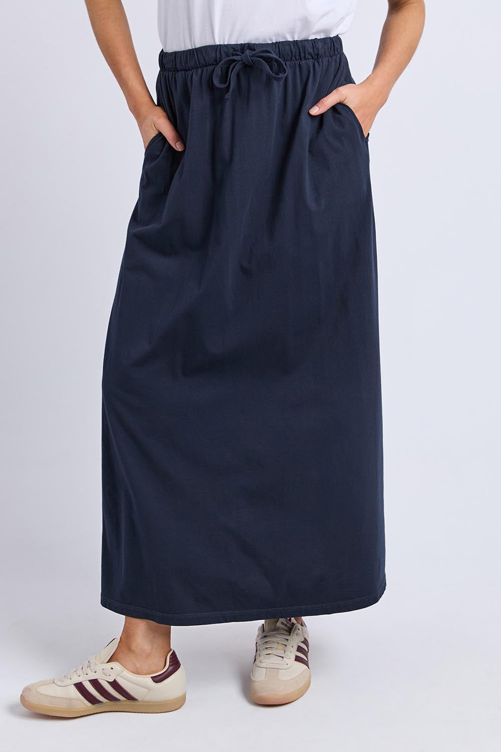 A model wearing the Evolve Cotton Skirt in colour Navy (Blue), from the front, cropped image