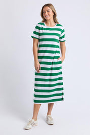 A model wearing the Tallow Cotton Dress in colour Whtgreen, from the front, showing the whole outfit