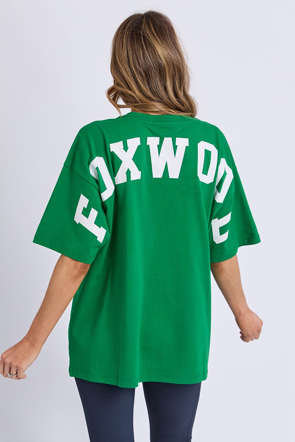 A model wearing the Interval Cotton Tee in colour Green (Green), from the back