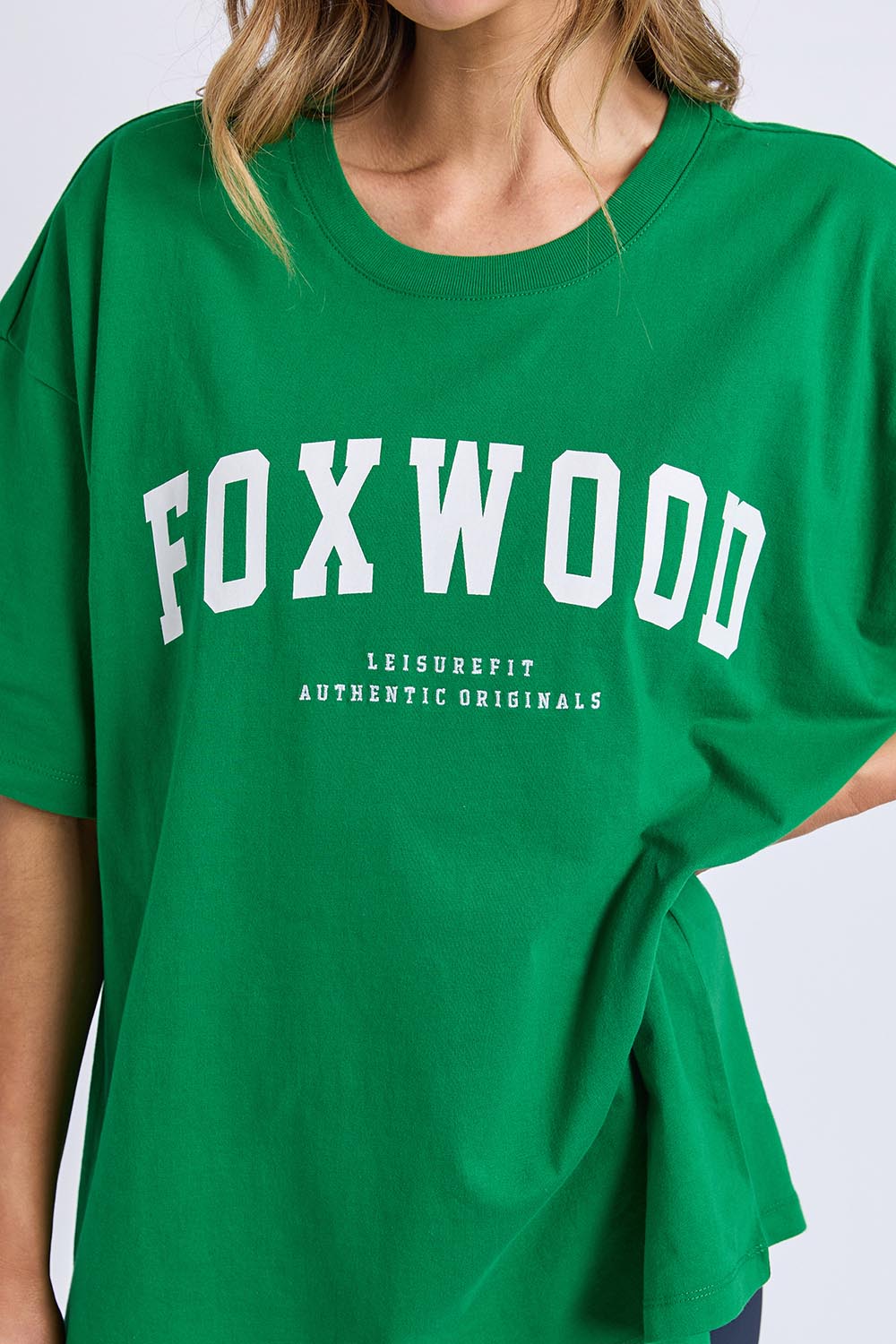 A model wearing the Interval Cotton Tee in colour Green (Green), from the front, cropped image