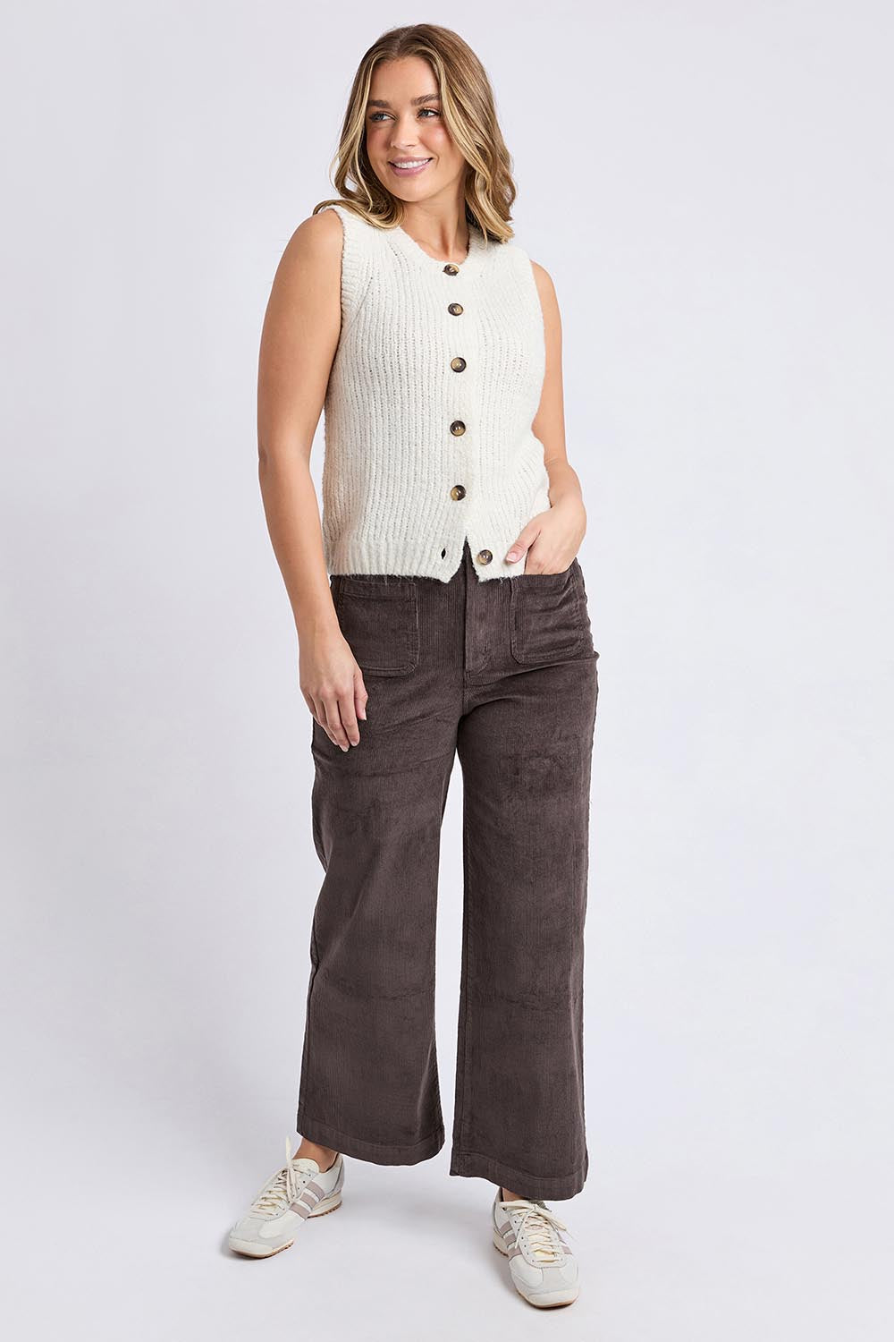A model wearing the Delta Knit in colour Vinwhite (White), from the front, showing the whole outfit