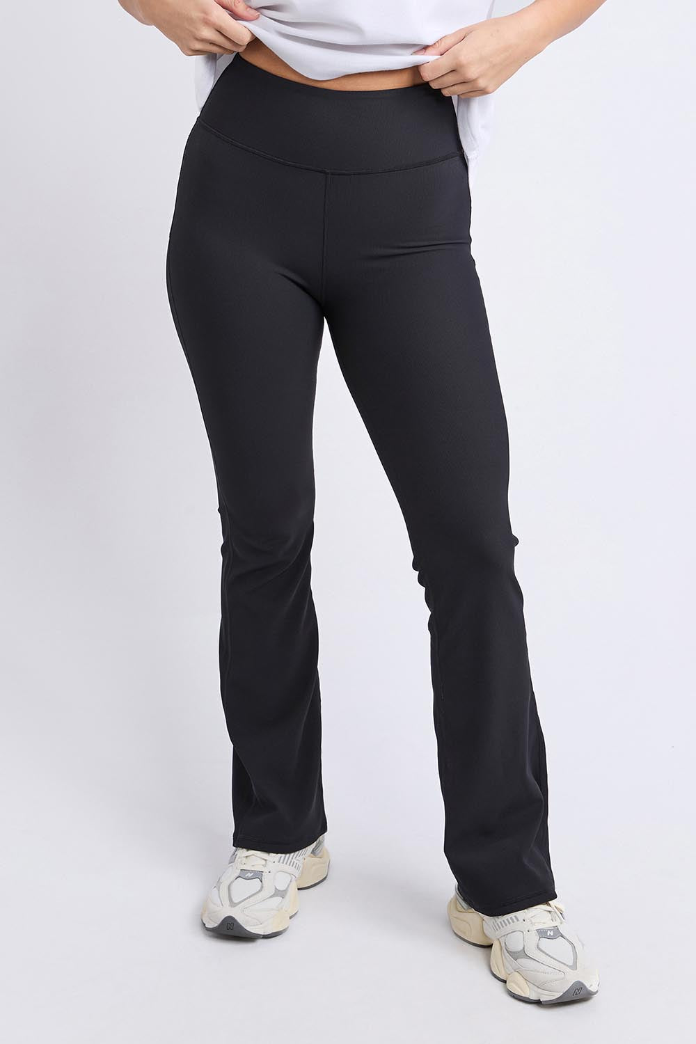 A model wearing the Elements Luxe Rib Pant in colour Black (Black), from the front, cropped image