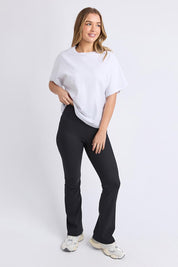 A model wearing the Elements Luxe Rib Pant in colour Black (Black), from the front, showing the whole outfit