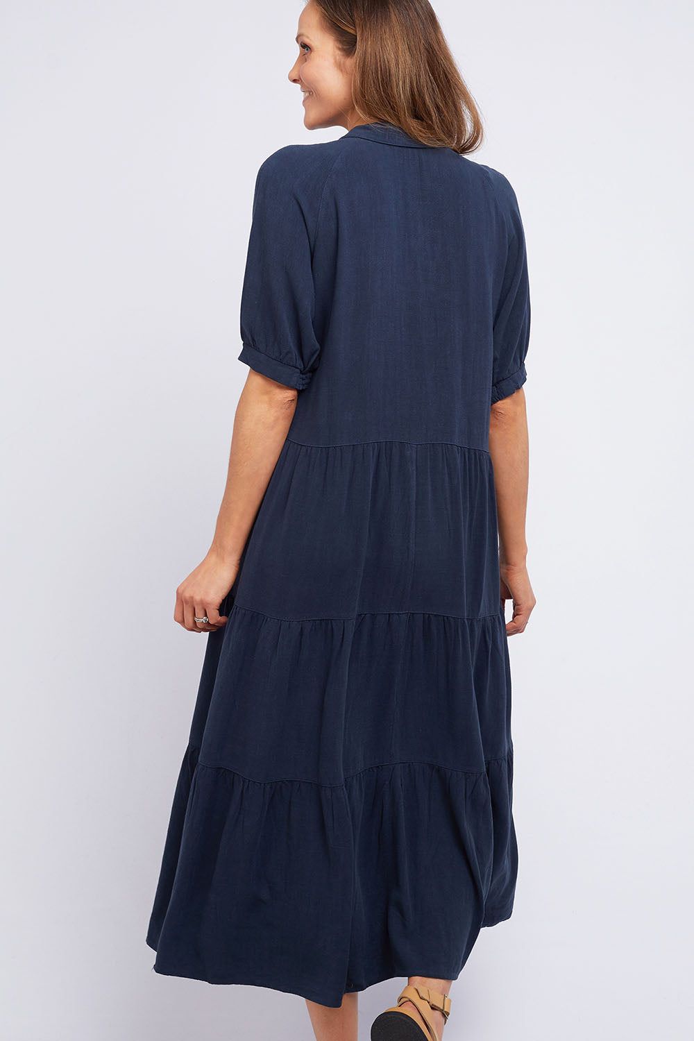 A model wearing the Sunny Days Dress in colour Navy (Blue), from the back