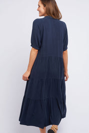 A model wearing the Sunny Days Dress in colour Navy (Blue), from the back